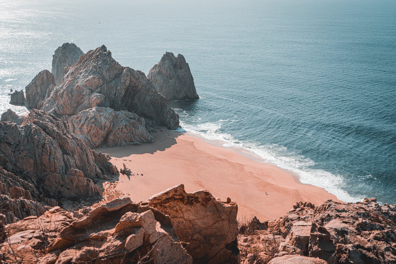 services-01 Serene Cabo San Lucas beach view with rocky formations and a tranquil ocean scene.