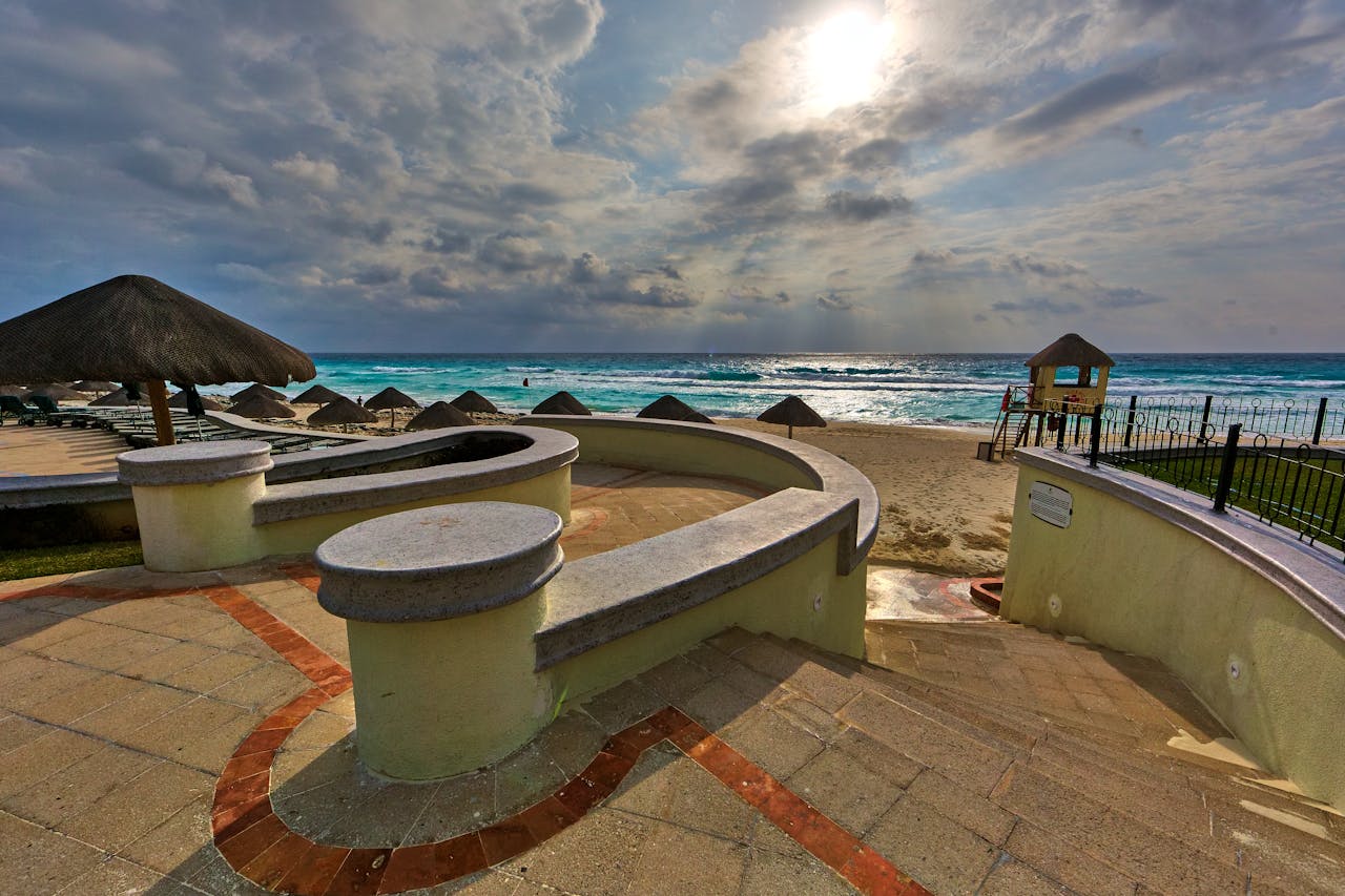 our-services-1 A serene beach resort with ocean views, perfect for relaxation and leisure under a dramatic sky.